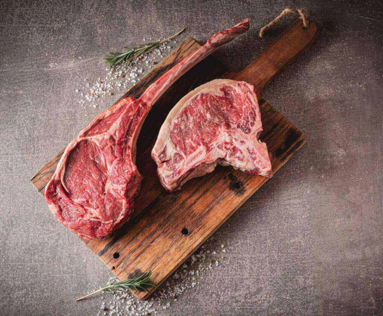 Leckere Steaks am Knochen auf einem Brettchen
