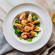 Frischer Salat mit Black Tiger Garnelen, Spinat, Eiern und Pineienkernen