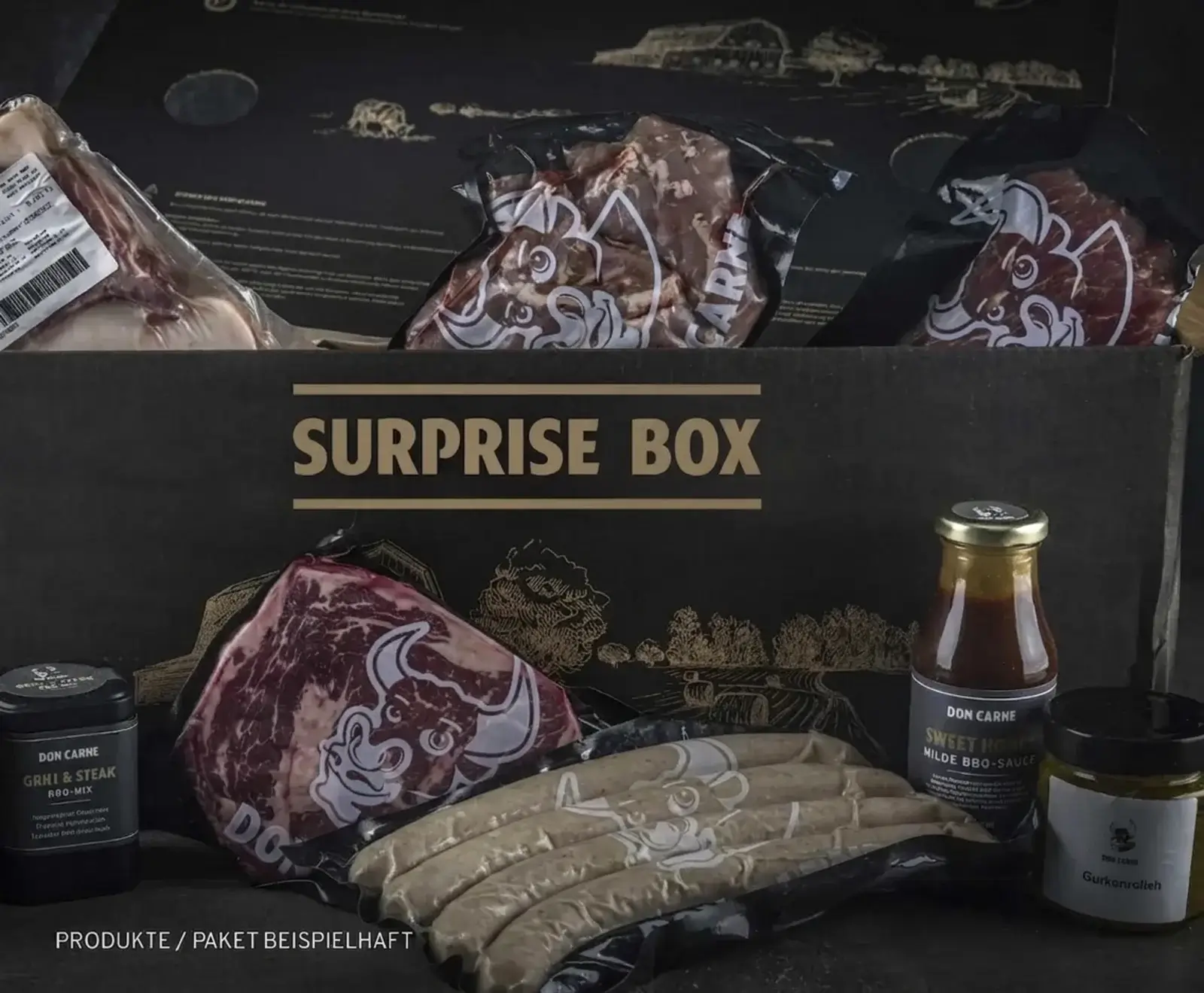 Eine schwarze "DON CARNE SURPRISE BOX" gefüllt mit vakuumverpacktem Fleisch (Steaks, Würste), einer BBQ-Sauce, einem Grillgewürz und Gurkenrelish. Der Hintergrund zeigt goldene Landschaftsillustrationen.