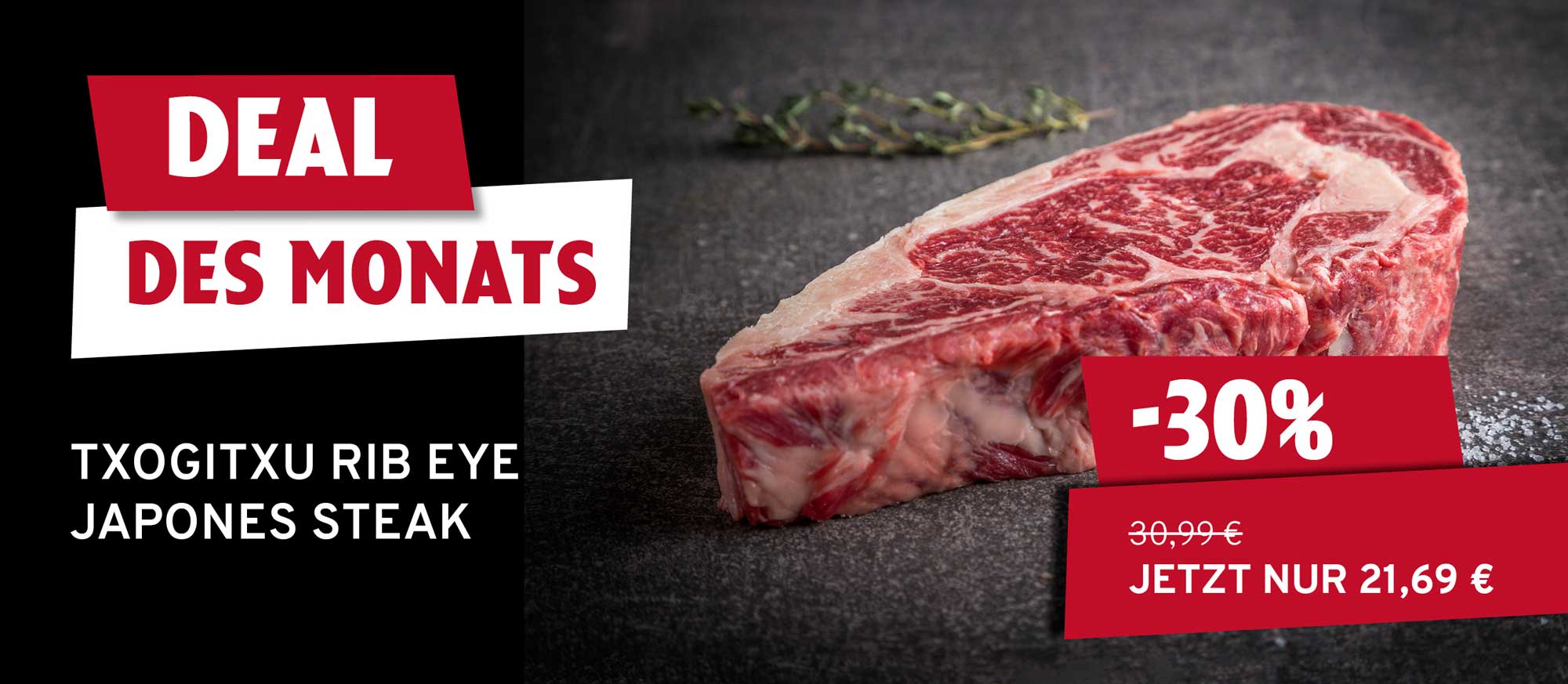 Rohes Txogitxu Rib Eye Japones Steak auf dunklem Untergrund mit Kräutern. Links "DEAL DES MONATS" und Steak-Name. Rechts "-30%", alter Preis 30,99€, neuer Preis 21,69€.