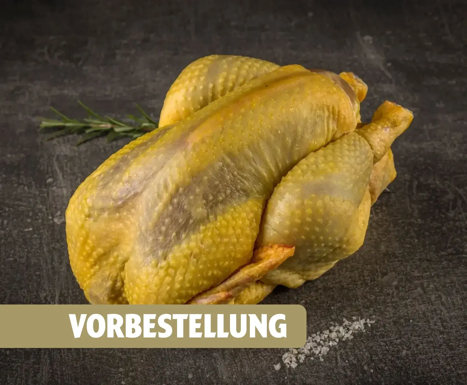 Ein ganzes, rohes Maishähnchen mit gelber Haut liegt auf einer dunklen Oberfläche, daneben ein Rosmarinzweig und grobes Salz. Unten ist ein Banner mit dem Text 'VORBESTELLUNG' eingeblendet.