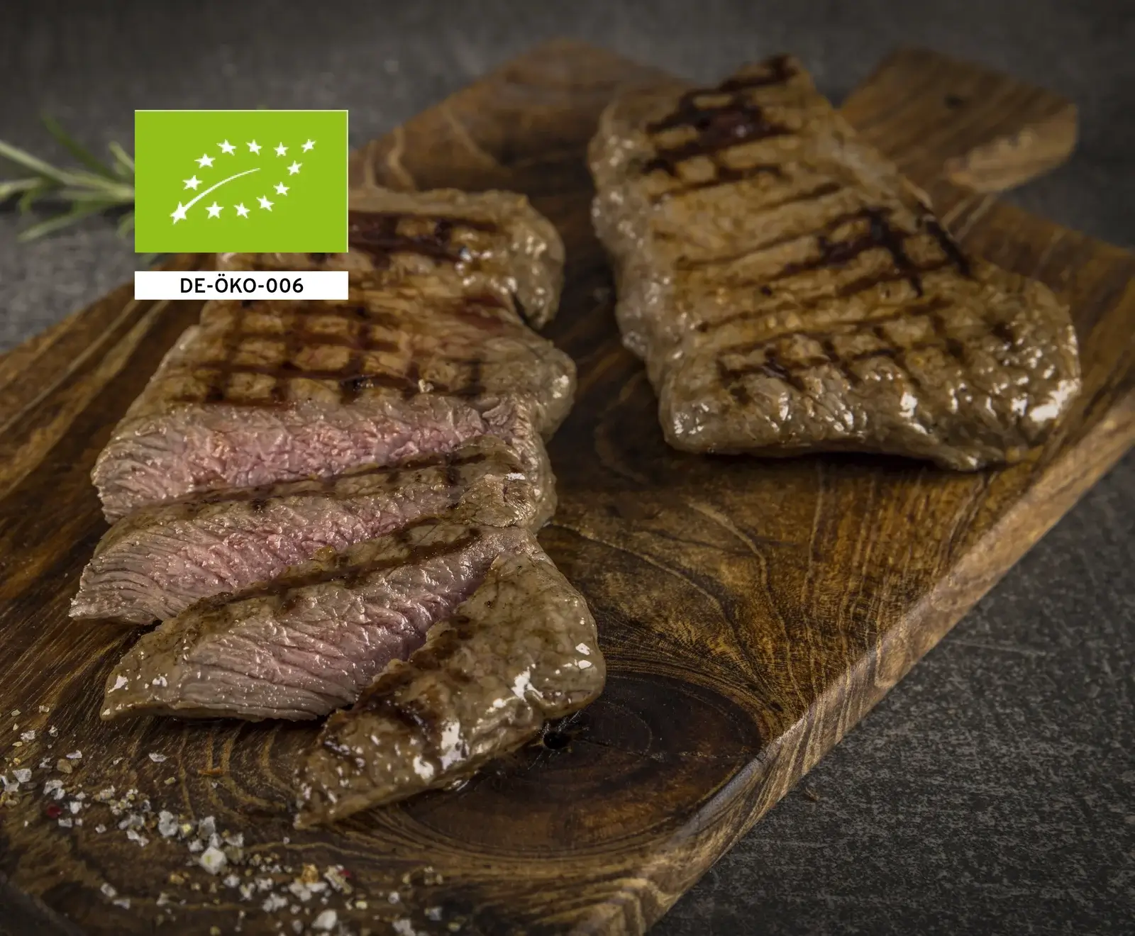 Bio-Rindersteaks auf einem Holzbrett, mit EU-Bio-Siegel gekennzeichnet