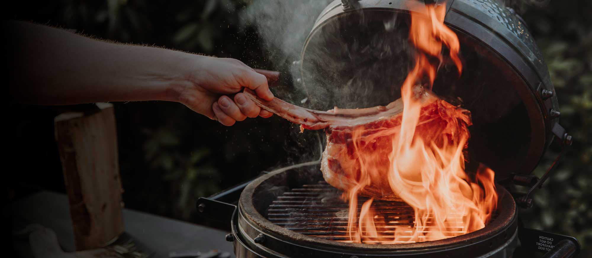T-Bone Steak wird auf Kugelgrill gelegt