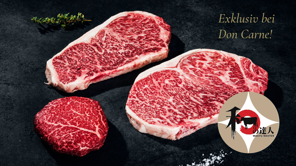 Drei rohe, stark marmorierte Rindersteaks liegen auf einer dunklen Oberfläche. Zwei große Steaks und ein kleineres Stück sind zu sehen, daneben ein Thymianzweig und Salz.