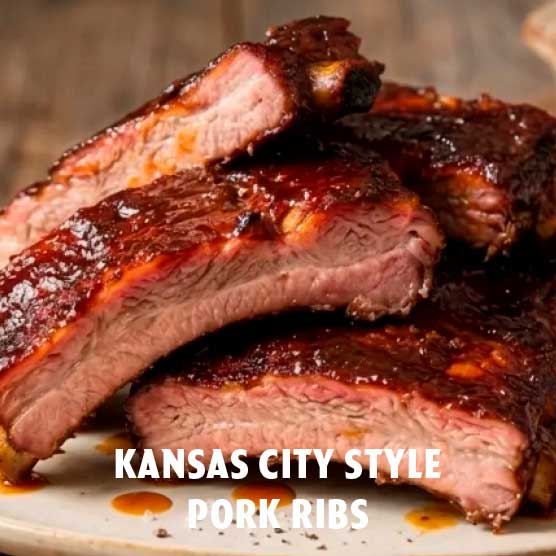 Mehrere saftige, zart aussehende Schweinerippchen im Kansas City Stil, großzügig mit glänzender, dunkler Barbecue-Sauce überzogen, liegen auf einem weißen Teller.