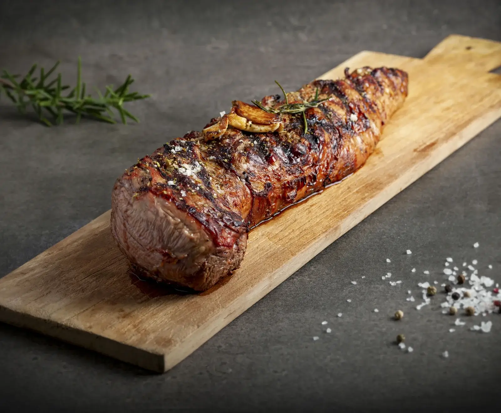 Gegrilltes Rinderfilet auf Schneidebrett, gewürzt mit Rosmarin und Meersalz