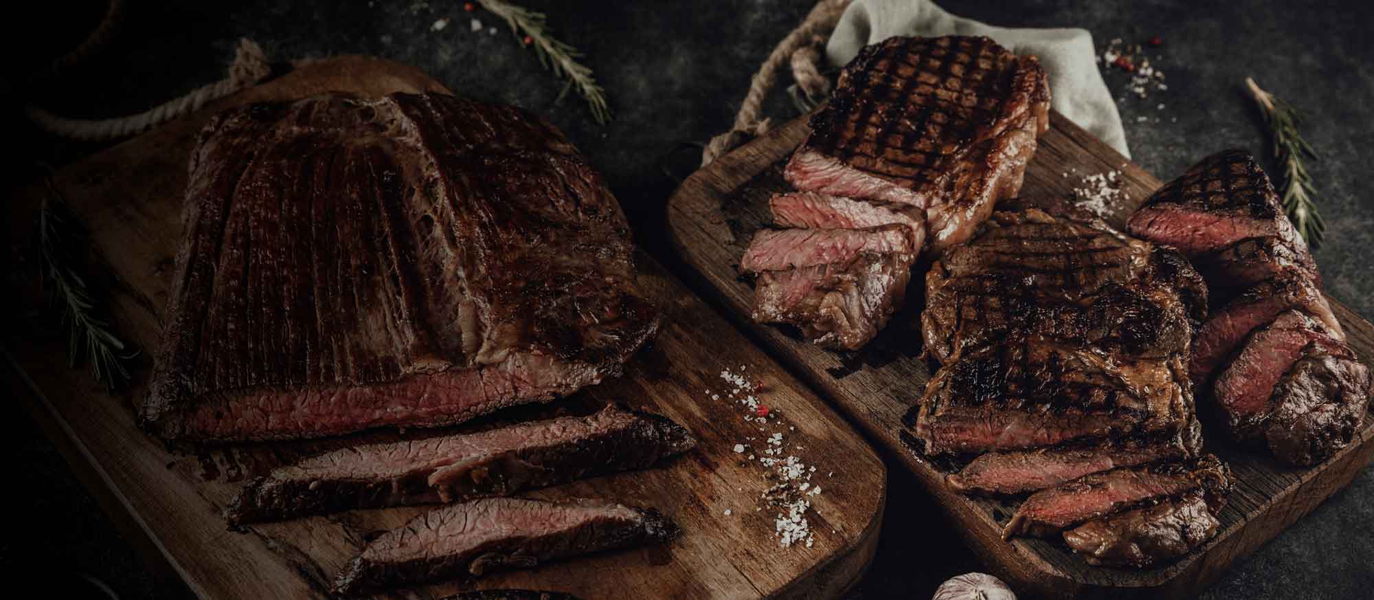 unterschiedlichste gegrillte Steaks auf Brettchen serviert