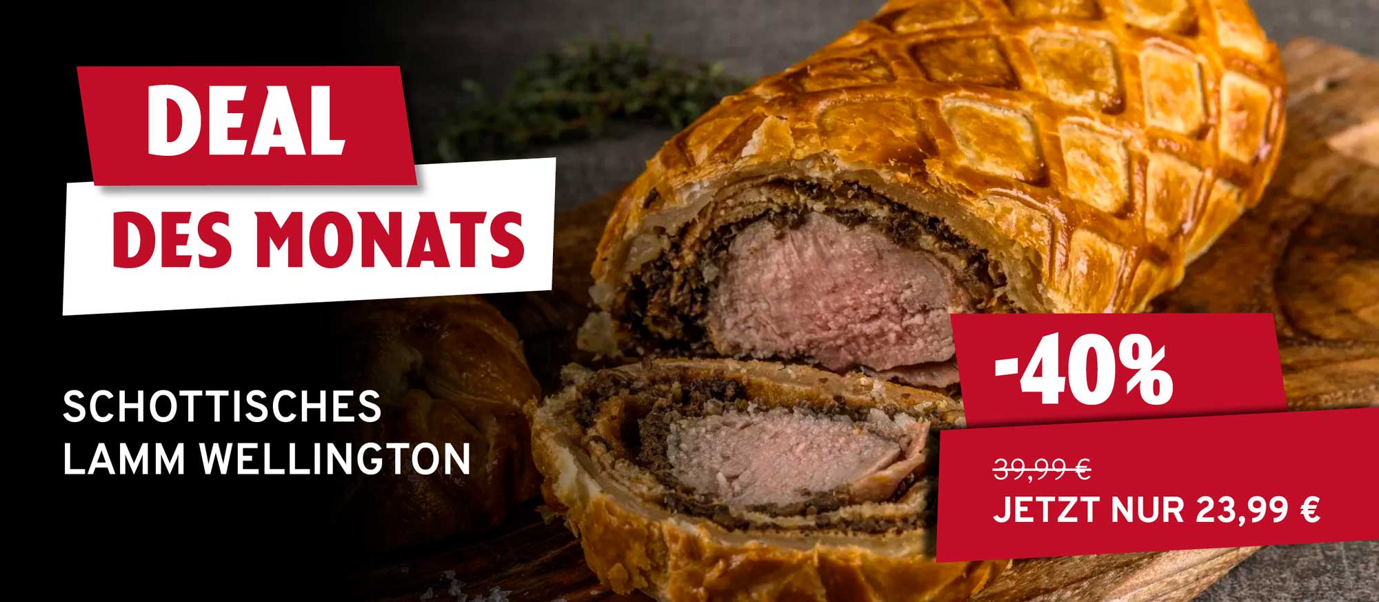 Ein angeschnittenes schottisches Lamm Wellington auf einem Holzbrett, mit goldbraunem Blätterteig und rosa Lammfleisch. Text: Deal des Monats, -40%, jetzt nur 23,99 €.