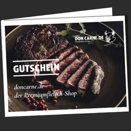 Ein saftiges, gegrilltes Steak, teilweise in Scheiben geschnitten, auf einem dunklen Teller mit Kräutern und rosa Pfeffer. Prominent steht "GUTSCHEIN" darauf, sowie "doncarne.de der Premiumfleisch-Shop" und das Don Carne Logo.