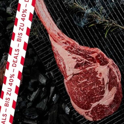 Tomahawk-Steak auf Rost über Holzkohle mit seitlichem Streifen