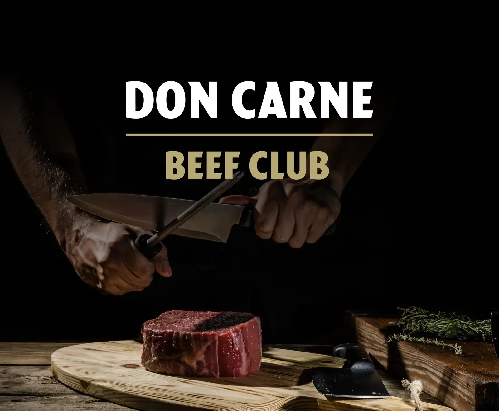 Hände schärfen ein Kochmesser mit einem Wetzstahl über einem rohen Rinderfilet auf einem Holzbrett. Im Hintergrund steht "DON CARNE BEEF CLUB". Daneben liegen Kräuter.