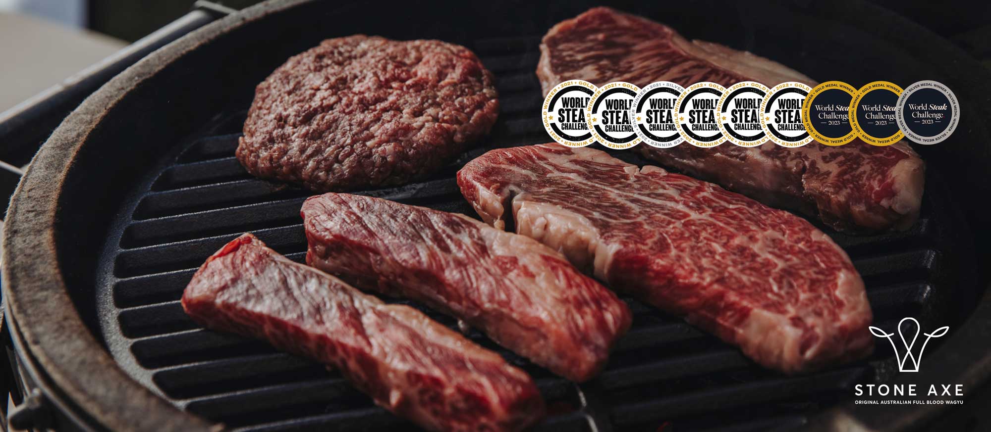 Rohe Steaks auf einem Kugelgrill mit Siegeln und Logo