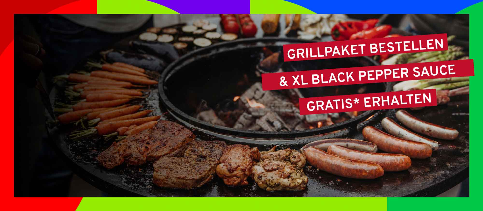Verschiedenes Grillgut wie Steaks, Würste und Gemüse auf einem großen runden Grill mit Feuerstelle. Rote Banner mit der Aufschrift: "GRILLPAKET BESTELLEN & XL BLACK PEPPER SAUCE GRATIS* ERHALTEN".